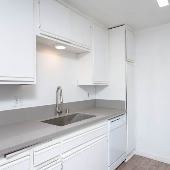 a kitchen with white cabinets and a white refrigerator.