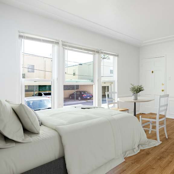 a bedroom with a bed and a desk and a tv