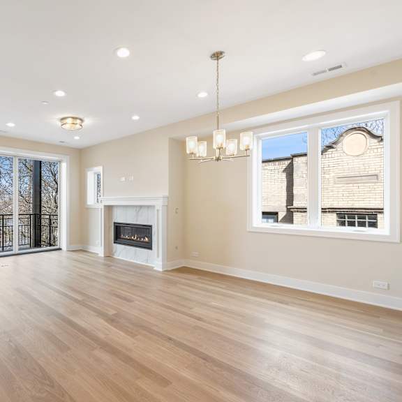 an empty living room with a fireplace and a large window