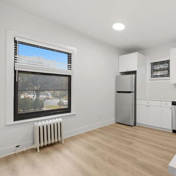 a kitchen with white cabinets and a stainless steel refrigerator.