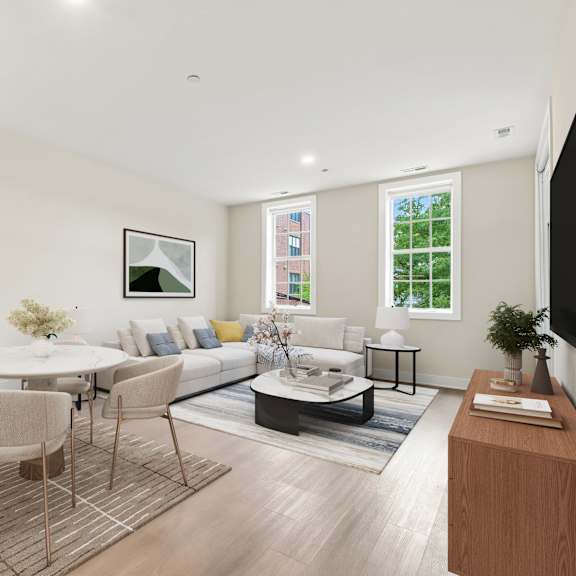 a modern living room with a white table and grey chairs.