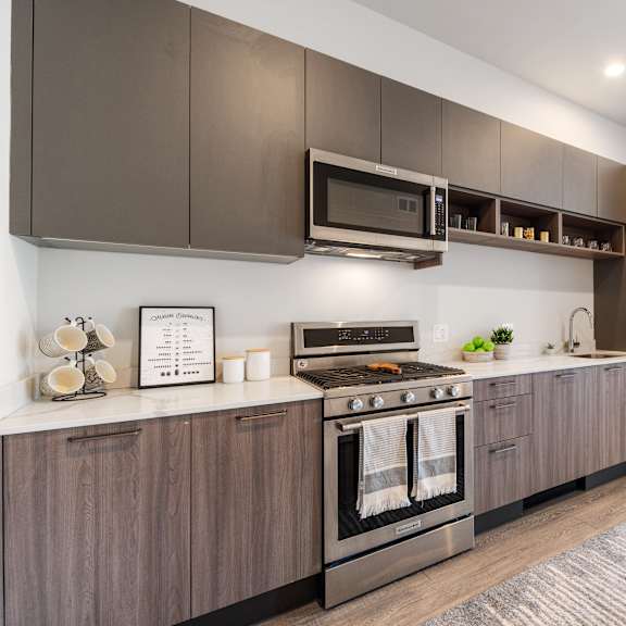 a kitchen with wooden grey cabinets and brand new stainless steel appliances