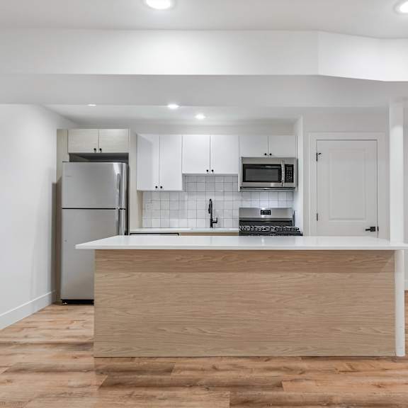 a kitchen with a wooden island and white walls.
