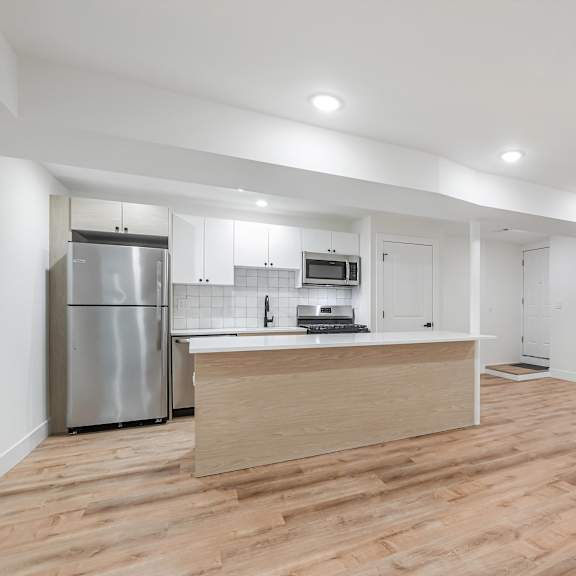 a kitchen with a refrigerator, microwave, and oven.