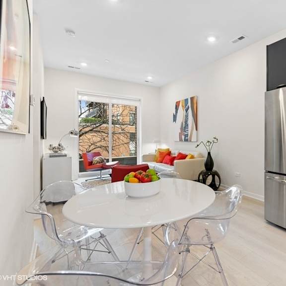 a kitchen with stainless steel appliances and a table and chairs