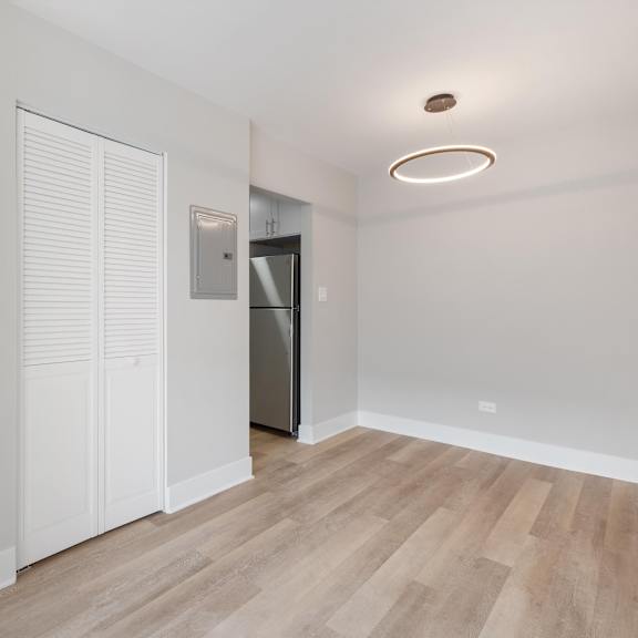 a bedroom with a medium hardwood floor and a doorway leading to a bathroom