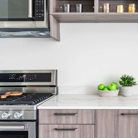 a close up of a kitchen with wooden cabinets and a white counter top