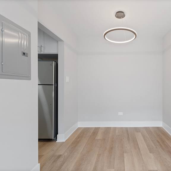 a bedroom with a medium hardwood floor and white walls