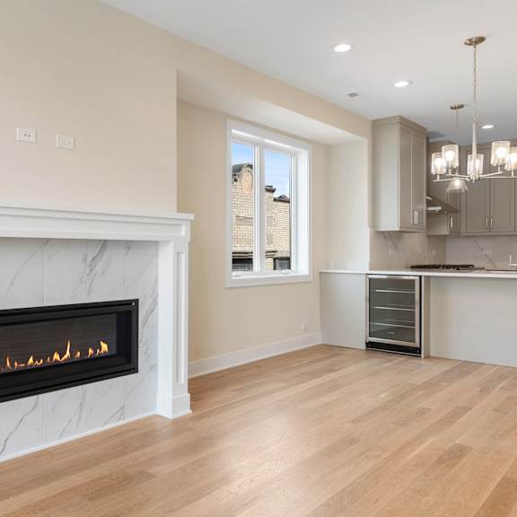 a living room with a fireplace and a kitchen