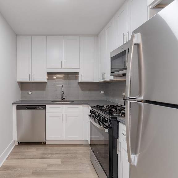 a kitchen with white cabinets and stainless steel appliances