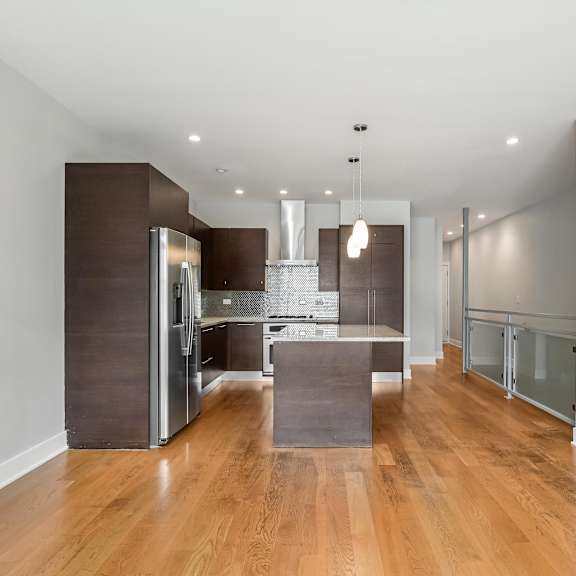 a modern kitchen with wooden floors and a large island.