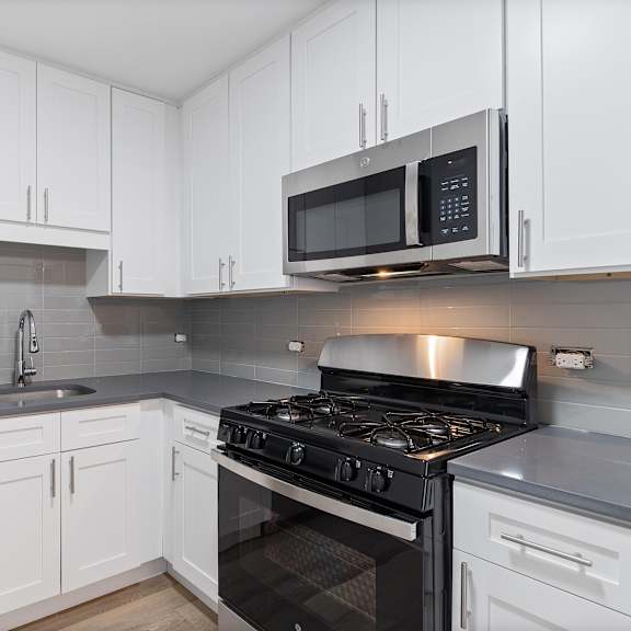 a kitchen with white cabinets and stainless steel appliances