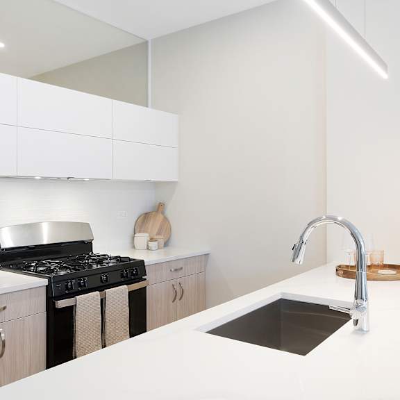 a modern kitchen with a white countertop and a black stove.