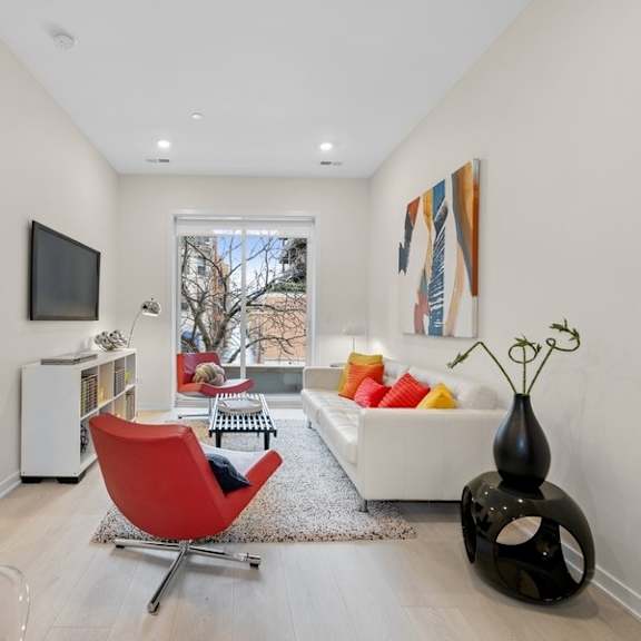 a living room with a couch and a chair and a television