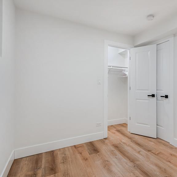 a white door is in a room with wood flooring.