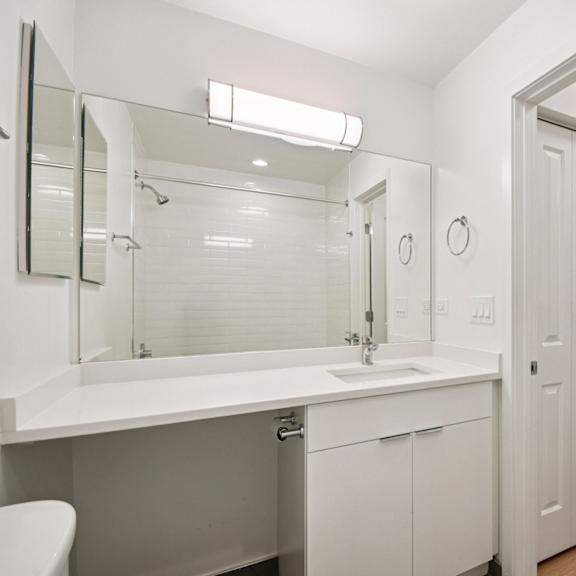 a white bathroom with a white toilet and sink.