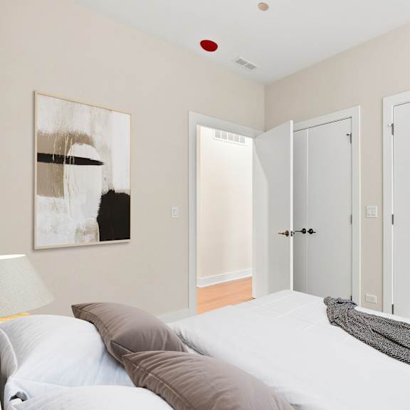 a bedroom with a bed, pillows, and a painting on the wall.