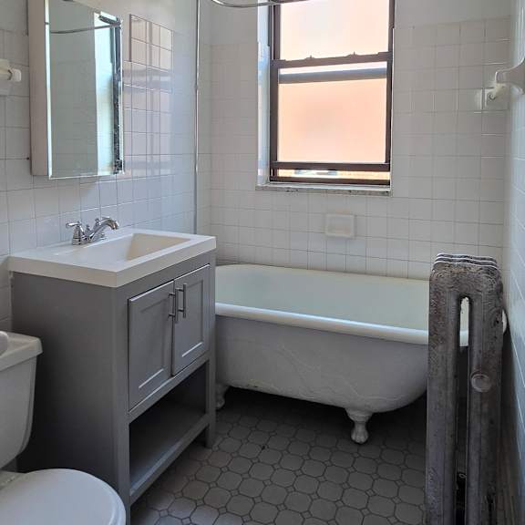a white bathroom with a toilet, sink, and shower.