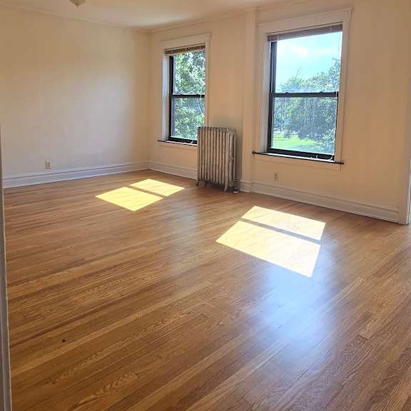 a room with a ceiling fan and wooden floors.
