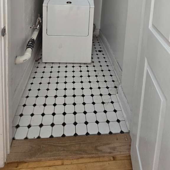 a white microwave oven is installed in a kitchen cabinet.