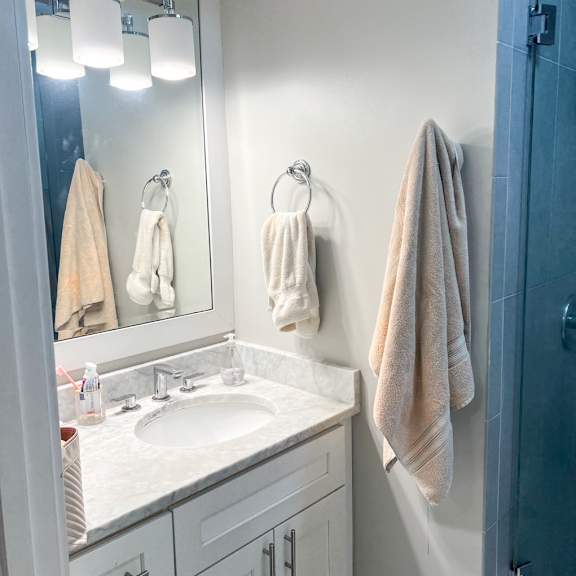 a small bathroom with white cabinets and a white sink