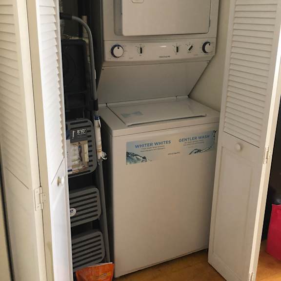 a white computer monitor with a grey keyboard is in a drawer.
