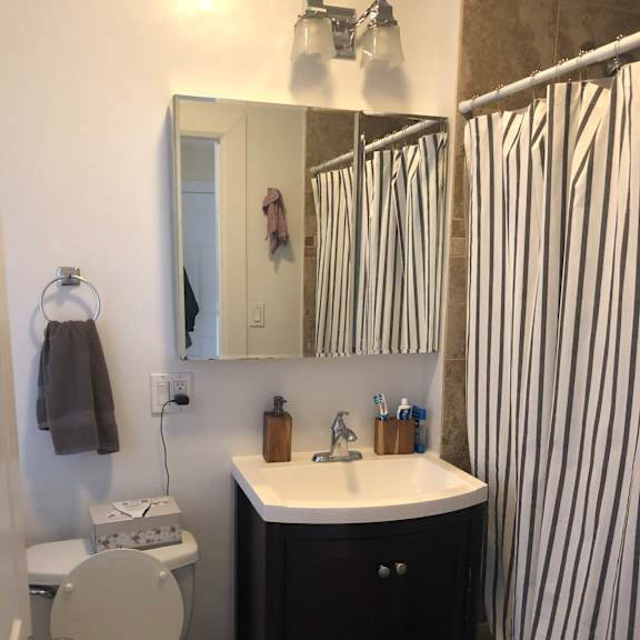 a bathroom with a toilet, sink, and mirror.