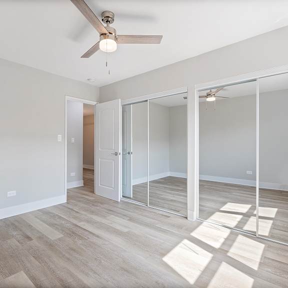 a bedroom with hardwood flooring and a ceiling fan