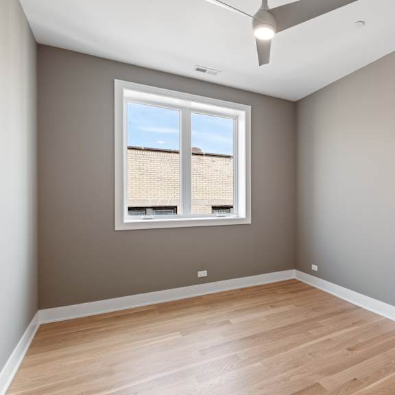 an empty room with wood floors and a window
