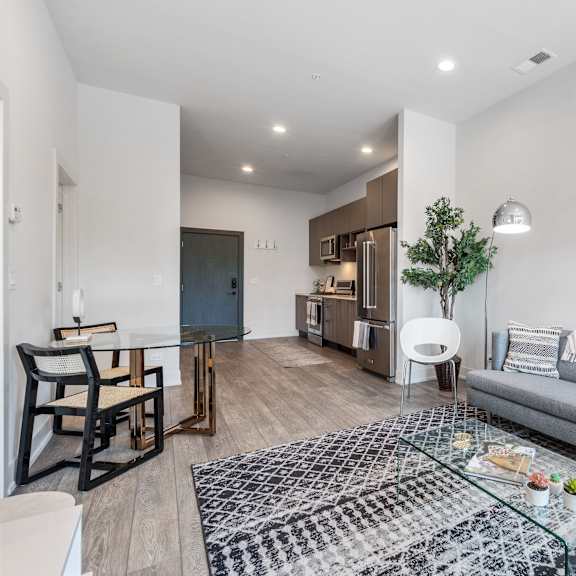 a contemporary living room with a gray couch and a glass coffee table