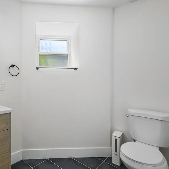 a white toilet sits next to a sink in a small bathroom.