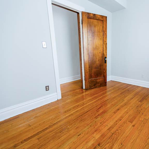 a room with a wooden floor and a wooden door