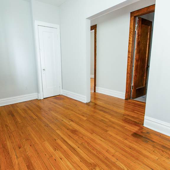 an empty room with wooden floors and a closet