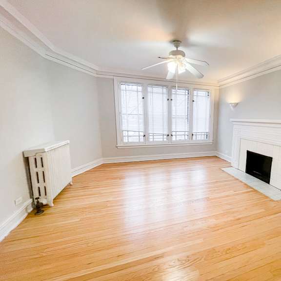 a room with a fireplace and a ceiling fan.