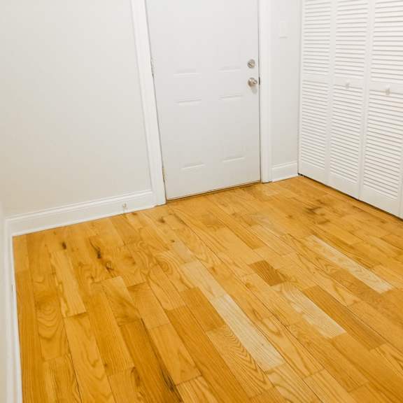 a room with wooden floors and white closet doors