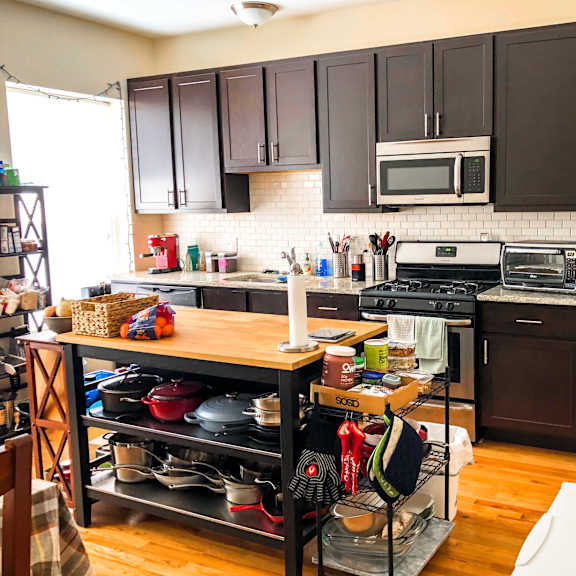 a kitchen with a refrigerator, oven, and microwave.
