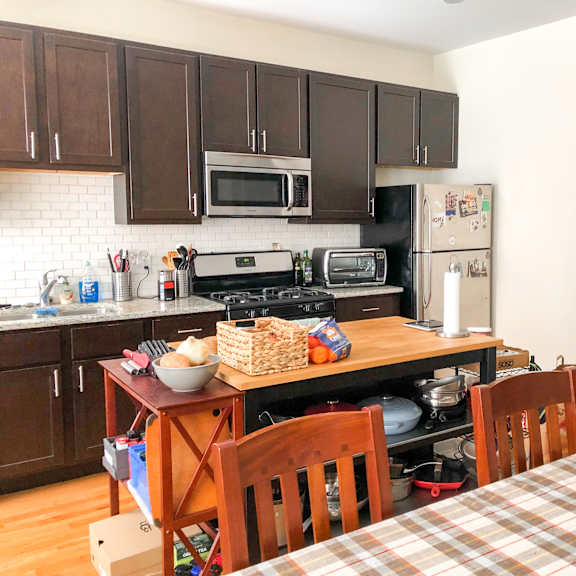 a kitchen with a table and chairs and a bookshelf.