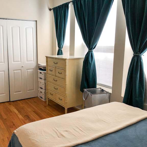 a bedroom with a bed, dresser, and wardrobe.