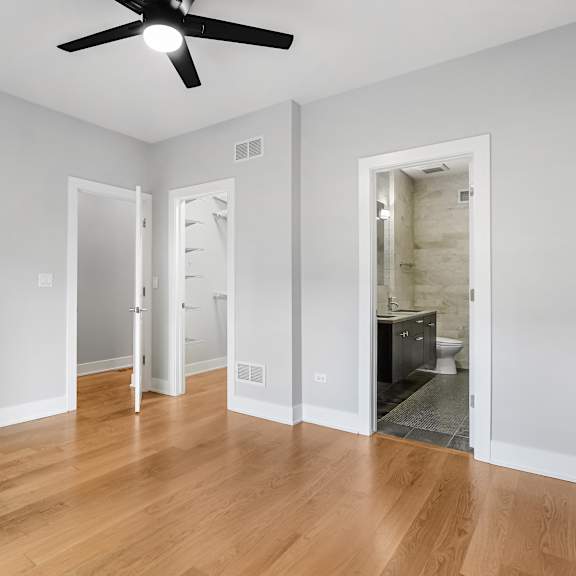 a room with a ceiling fan and wooden floors.