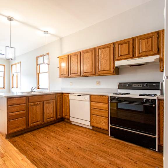 a kitchen with wooden cabinets and a white dishwasher.