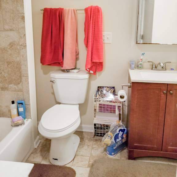 a bathroom with a toilet and two orange towels