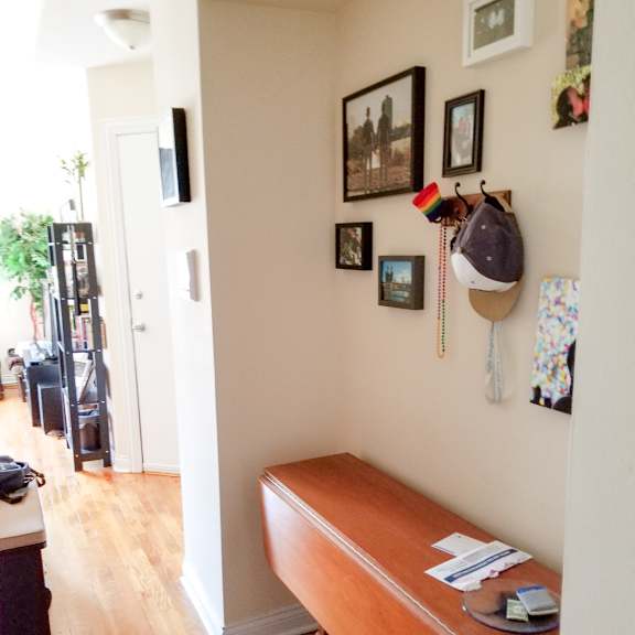 a room with a desk and a hat hanging on the wall