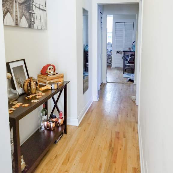a hallway with a wooden floor and white walls and a long hallway with white walls