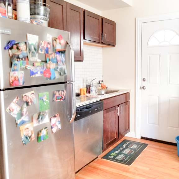 a kitchen with stainless steel appliances and a refrigerator covered in magnets