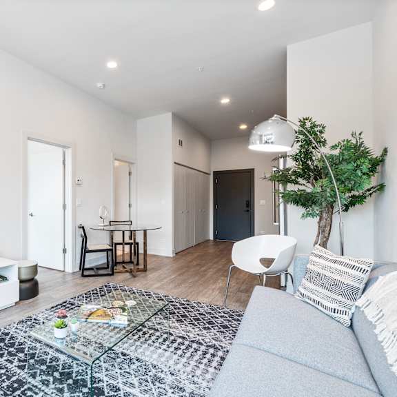 a living area with white walls and hardwood floors