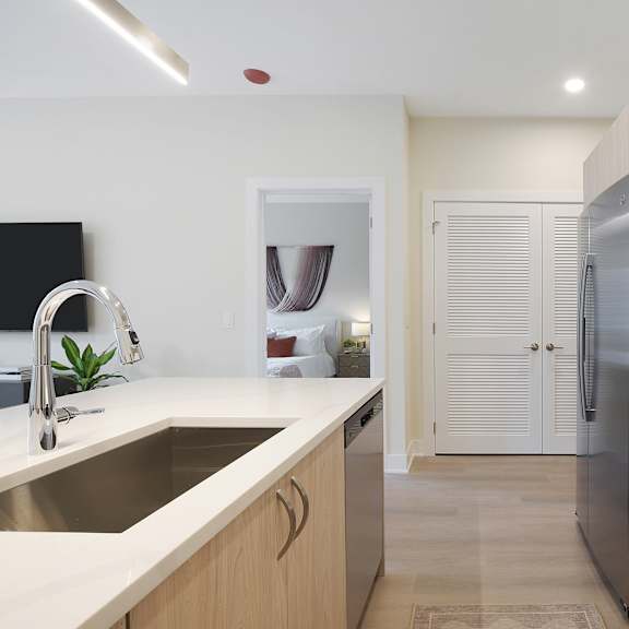 a modern kitchen with a sink, stove, and refrigerator.