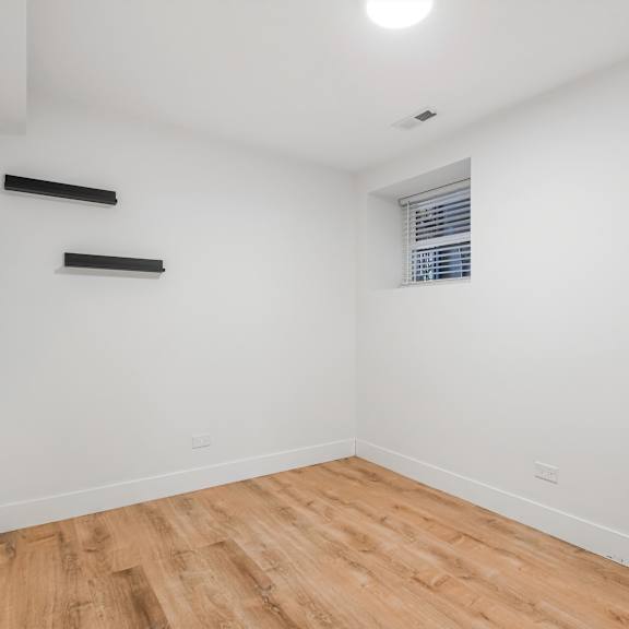 a room with wooden flooring and white walls.