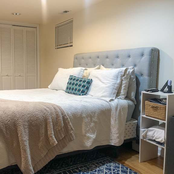 a bed with a white comforter and a blue pillow is in the image.