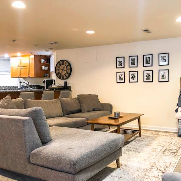 a living room with a grey couch, a wooden coffee table, and a flat screen tv.
