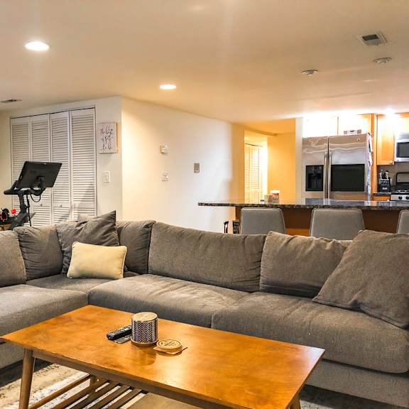 a grey couch with a wooden coffee table in front of it.